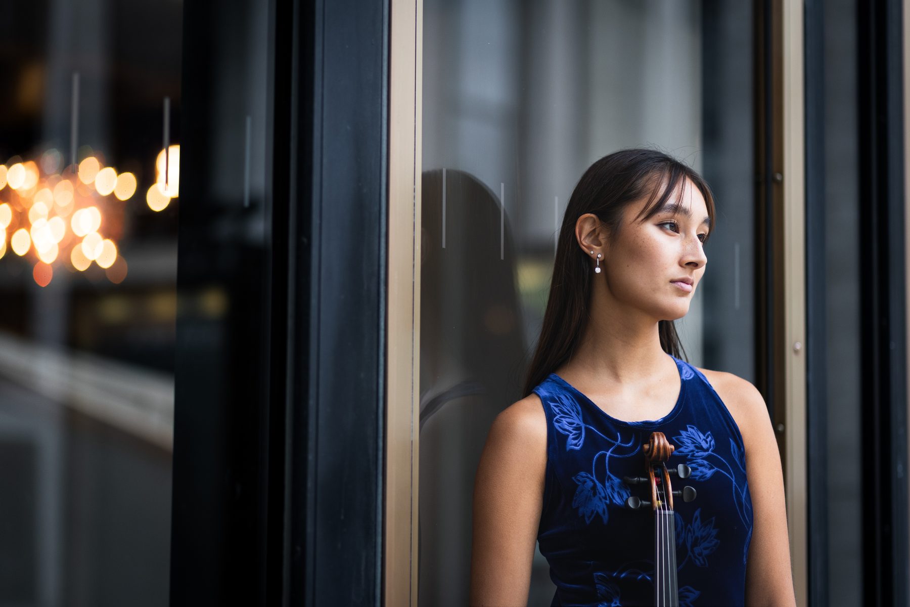 Maya Kilburn in a blue dress, seated editorial portrait