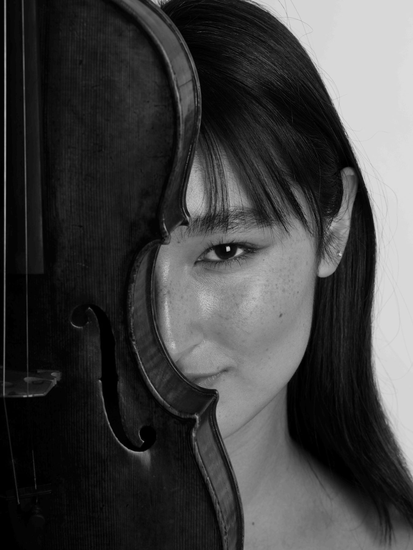 Maya Kilburn in a close black-and-white portrait with her violin